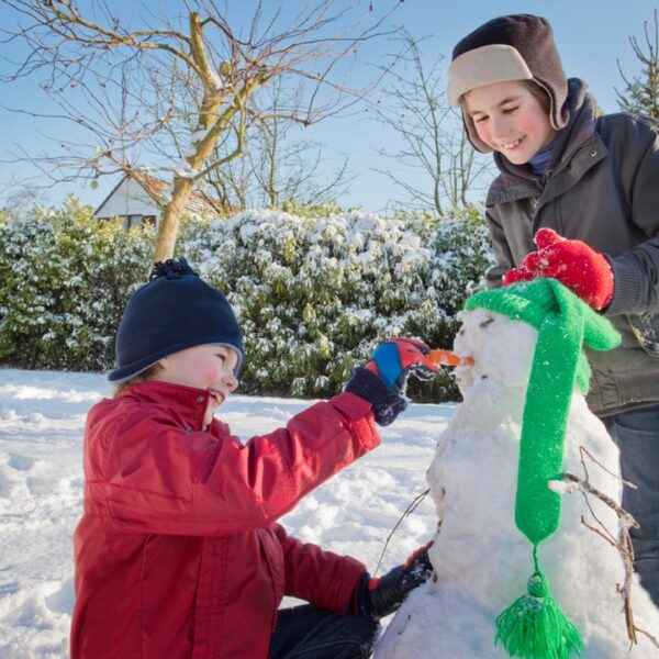 Bambini che giocano nella neve, pupazzo di neve